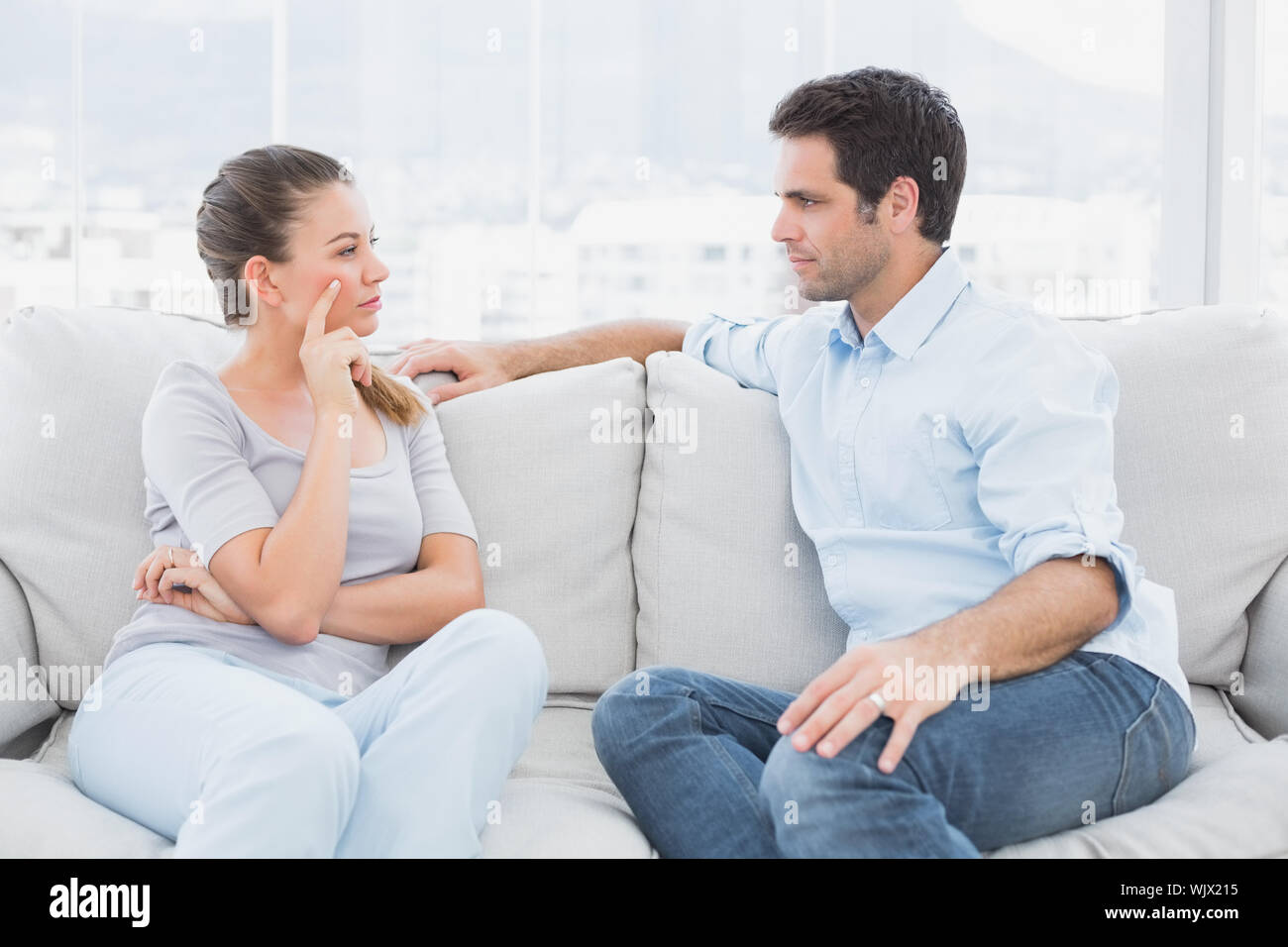 Couple having a serious discussion on the couch at home in the living