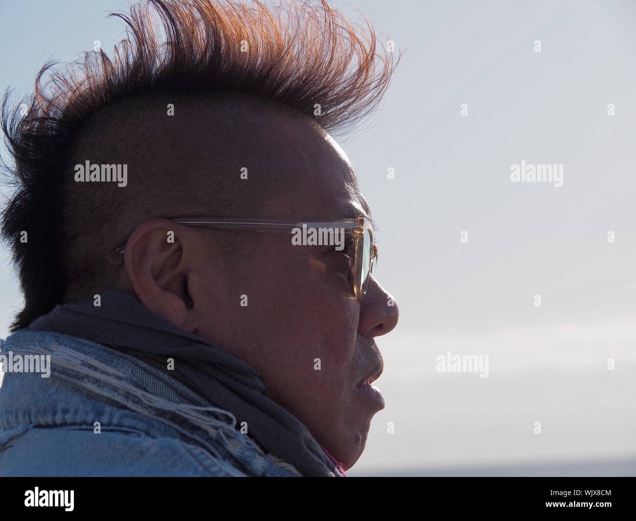 Side View Of Serious Mid Adult Man With Mohawk Hairstyle Against