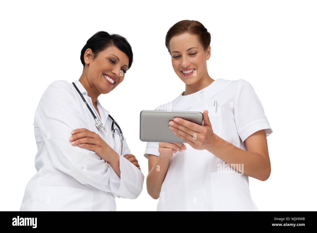 Two female doctors using digital tablet over white background Stock Photo