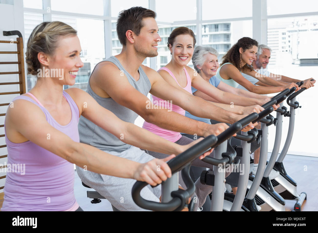 Group portrait of happy people working out at spinning class in gym Stock Photo Alamy