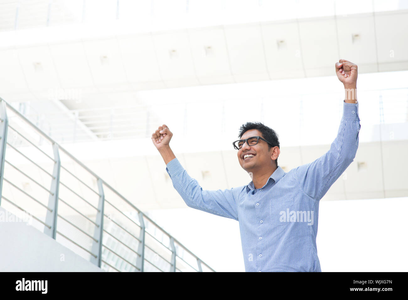Successful Asian Indian businessman with arms up celebrating his ...