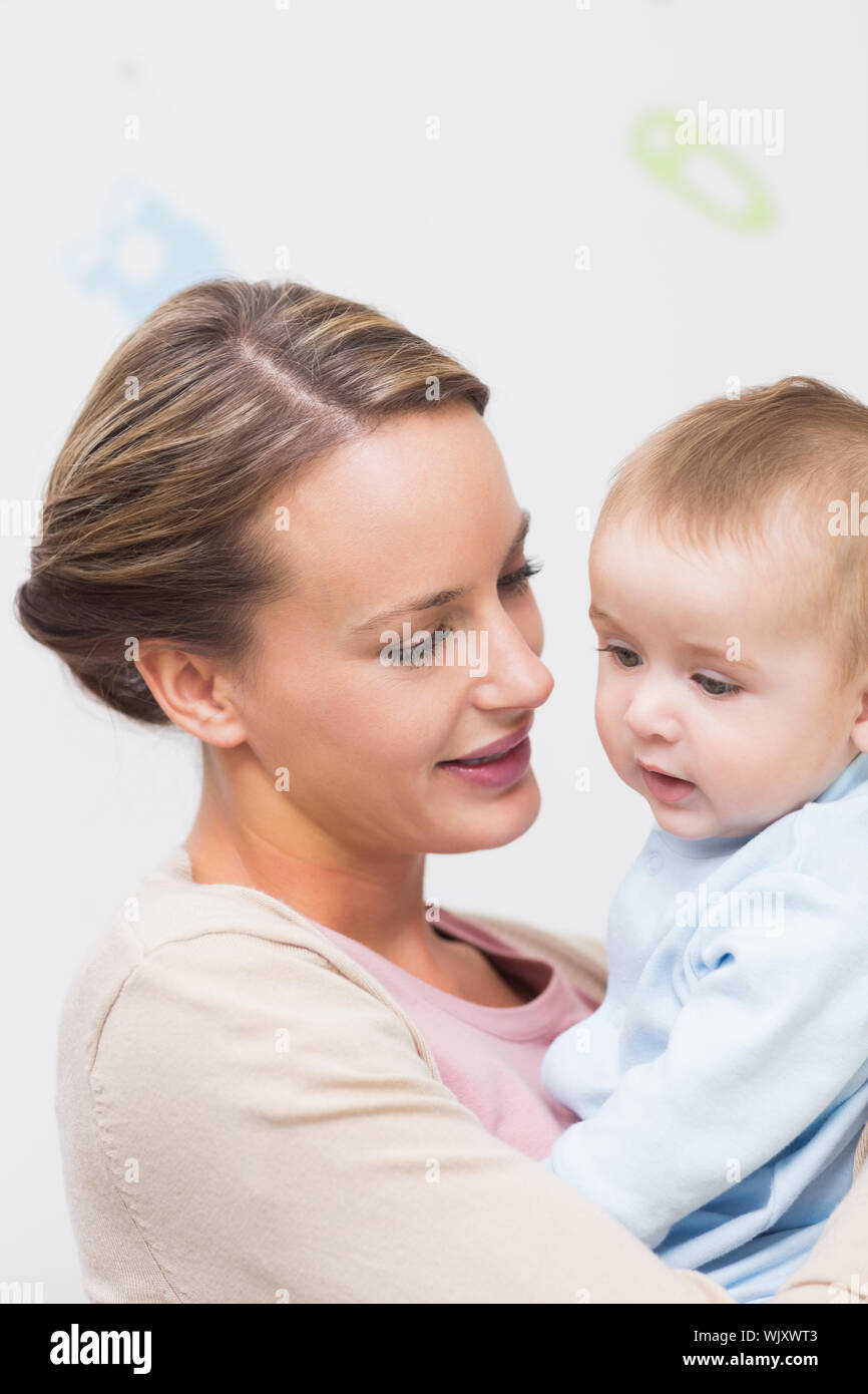 Loving mother carrying baby boy at home Stock Photo Alamy