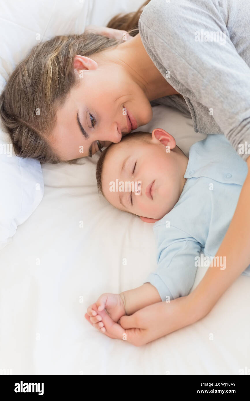 Mother sleeping with baby son on bed at home in bedroom Stock Photo Alamy