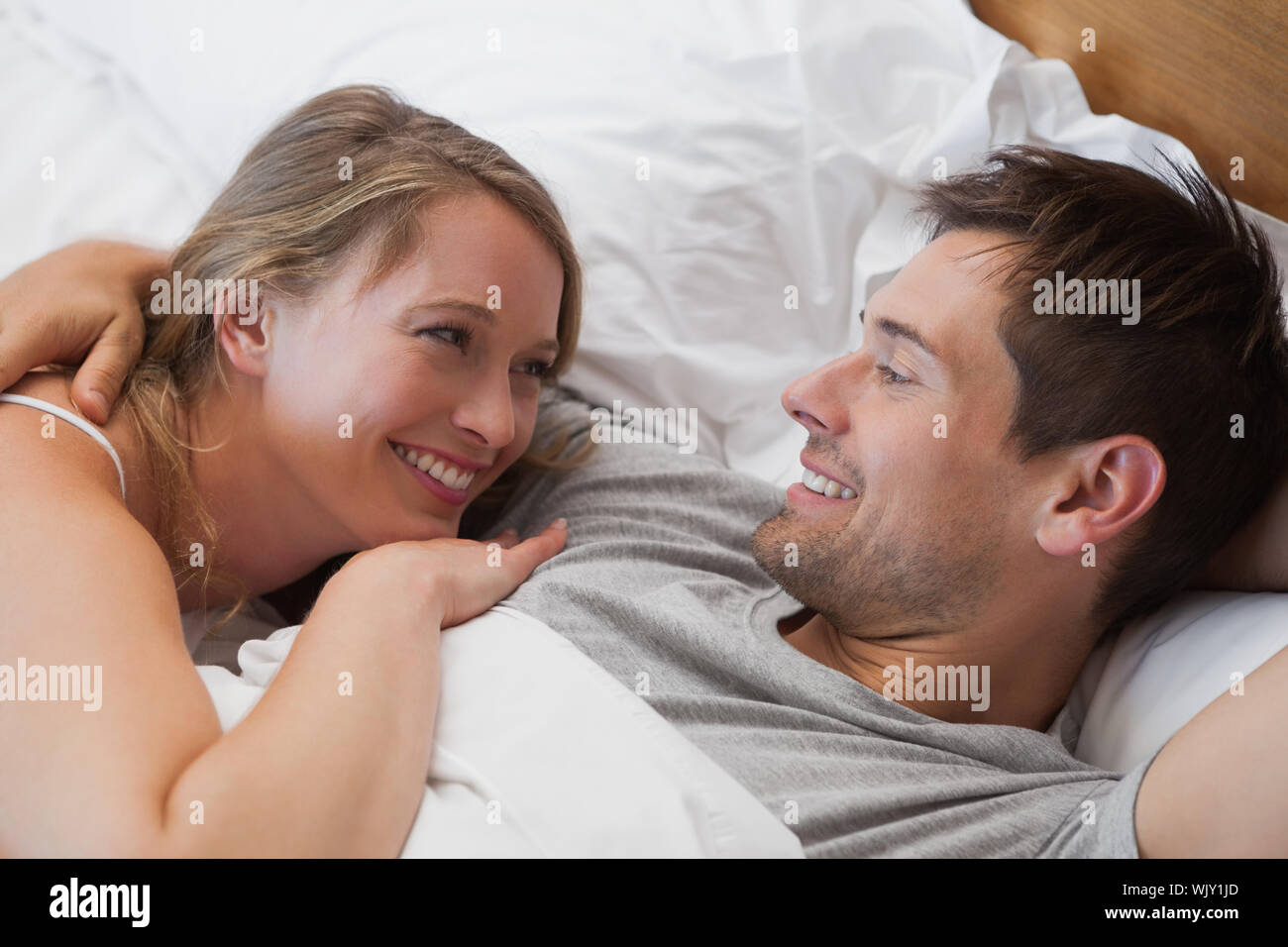 Close-up of a happy relaxed young couple together in bed at home Stock ...