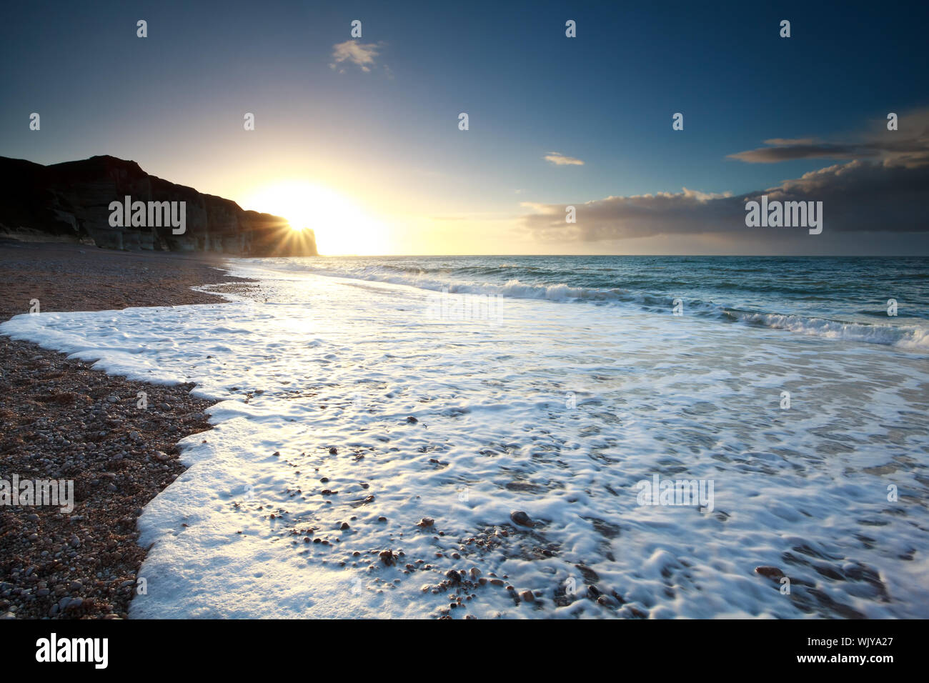 ocean waves on rocky beach at sunset, Etretat, France Stock Photo - Alamy