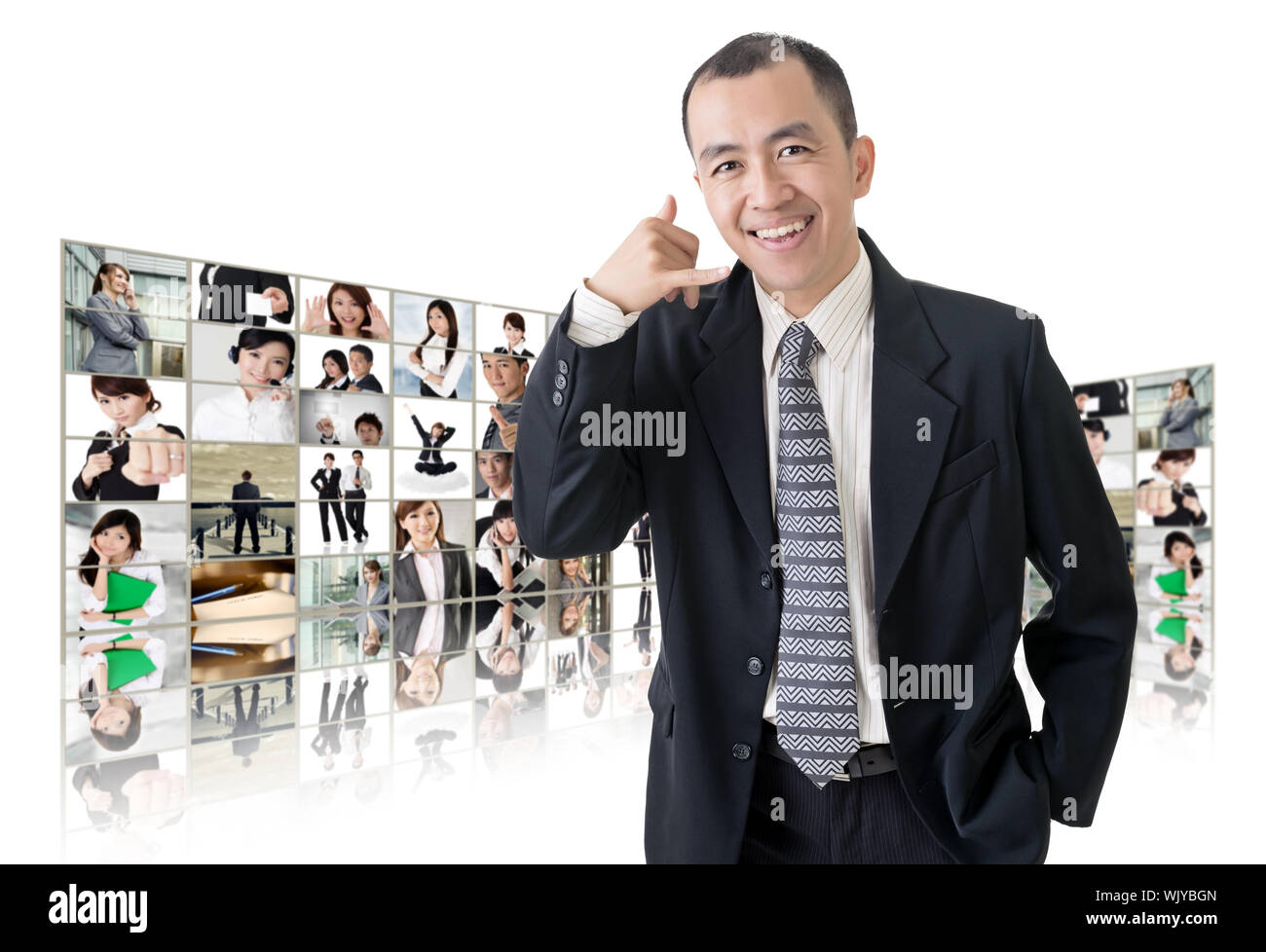 Asian business man or boss standing in front of tV screen wall showing pictures of business concept. Stock Photo