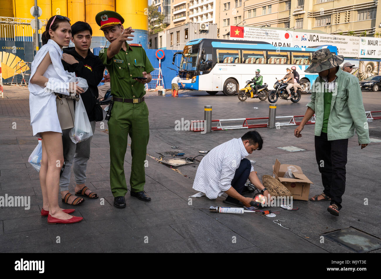 Policeman giving directions to tourists on Nguyen Hue Walking Street, Ho Chi Minh City, Vietnam Stock Photo