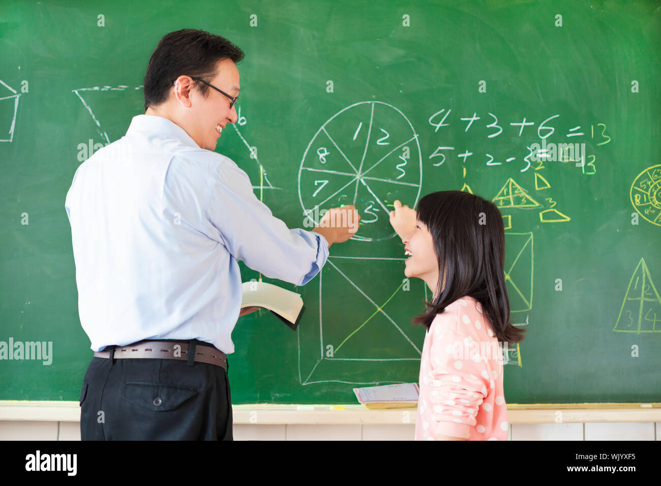Teacher teach student how to solve the math questions Stock Photo