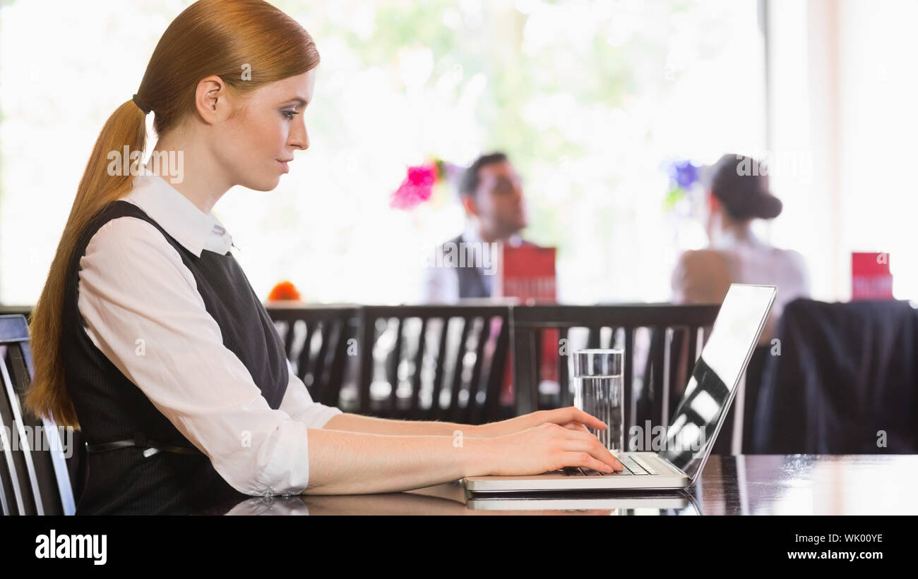 Concentrated businesswoman working on laptop Stock Photo