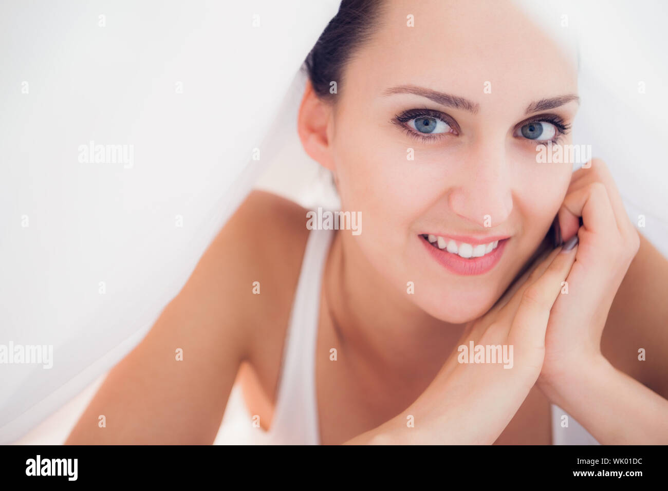 Happy lying under the sheets smiling Stock Photo Alamy