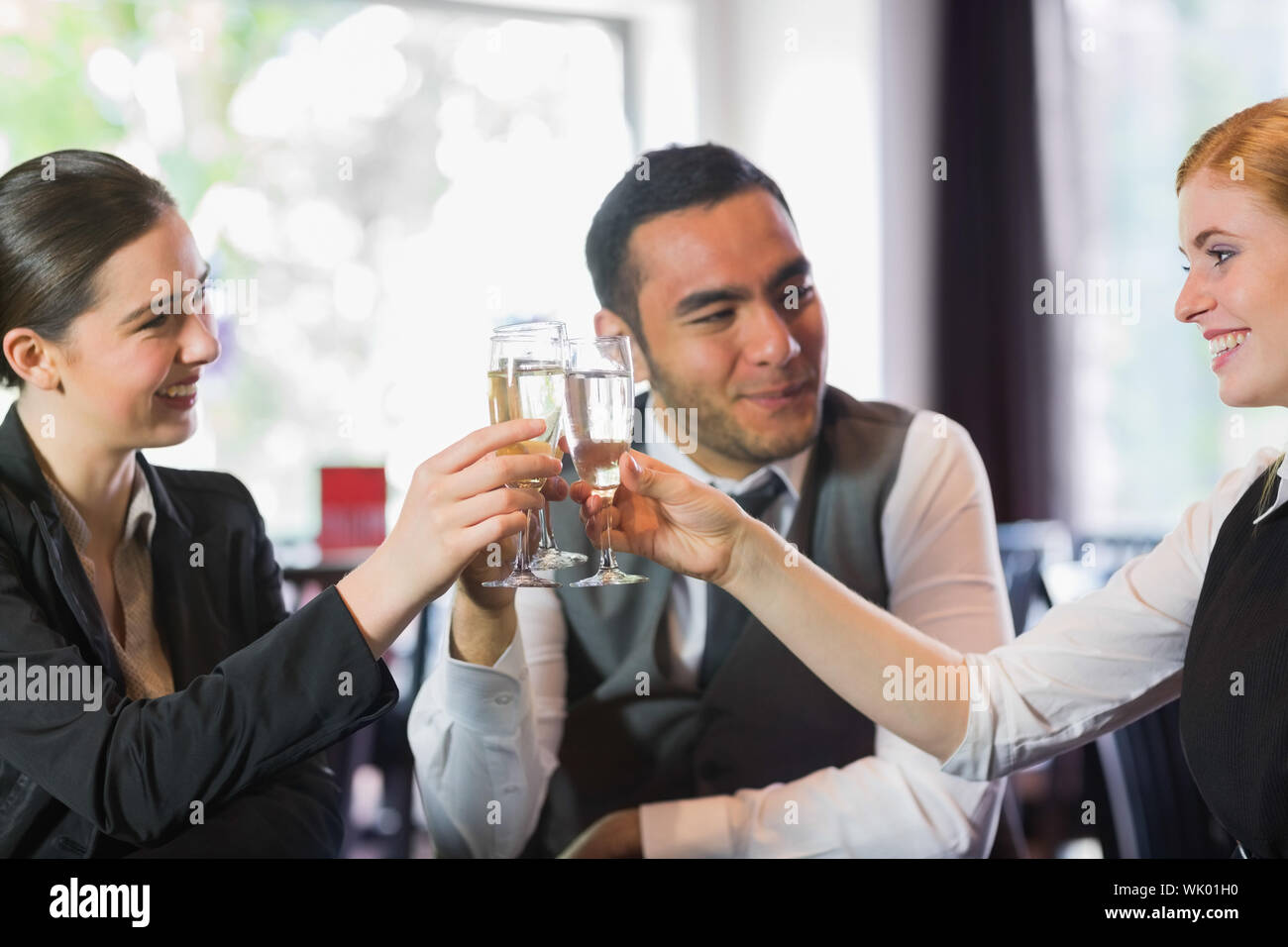 Happy business partners celebrating with champagne Stock Photo - Alamy