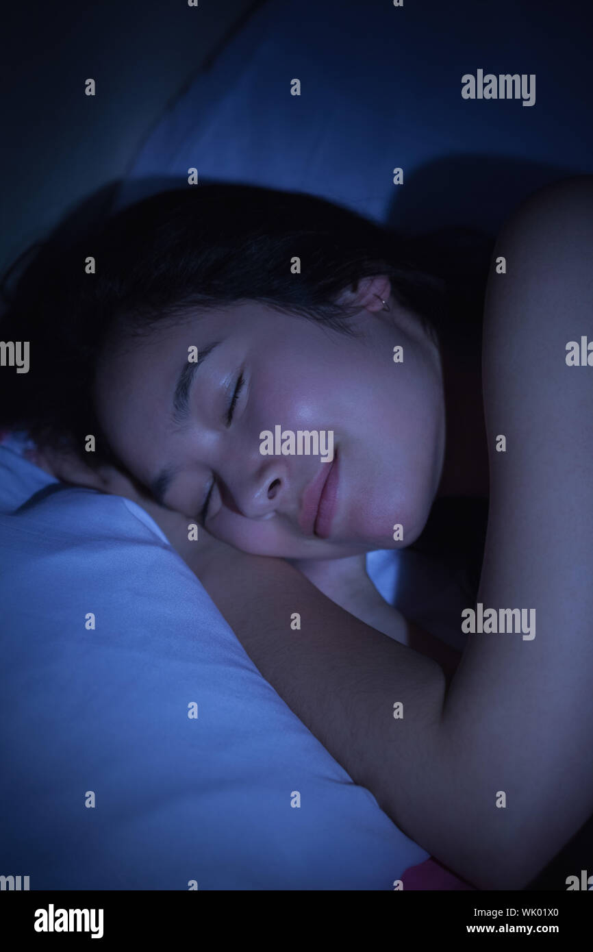 Young asian woman sleeping happily at night Stock Photo