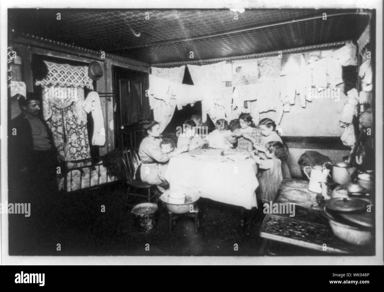 In a New York tenement house the whole family at work taking out the
