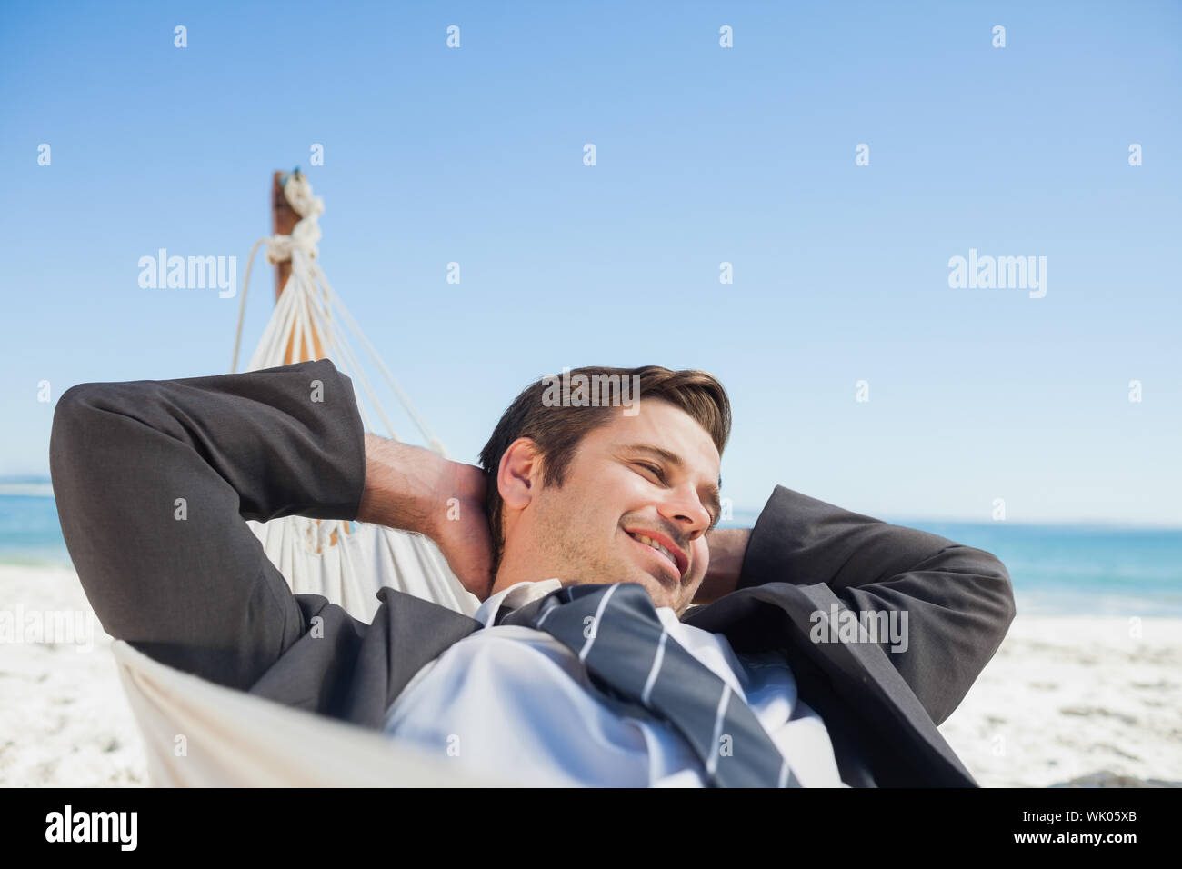 Businessman relaxing in hammock Stock Photo