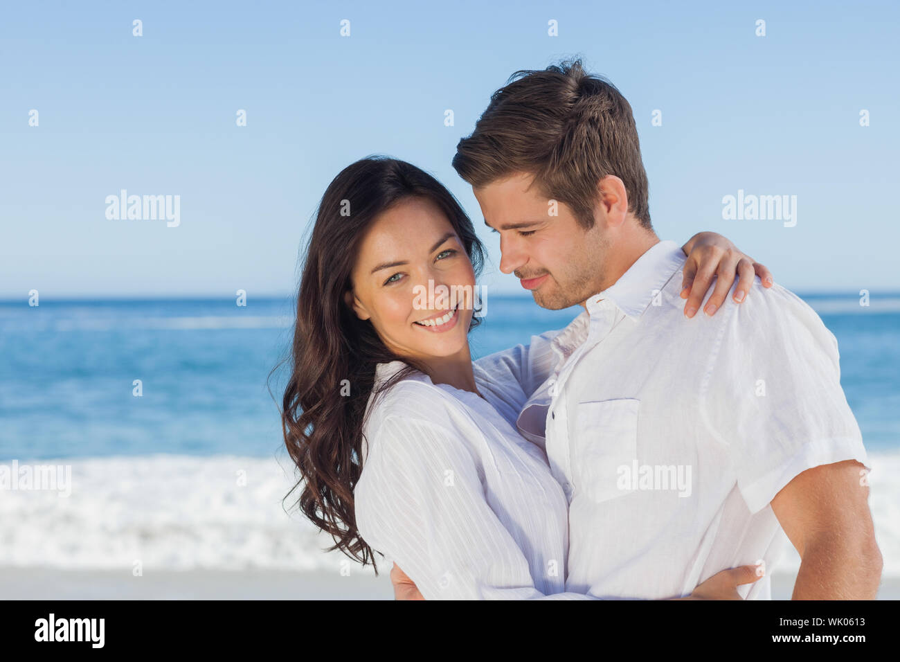 Young couple embracing and posing on the beach Stock Photo