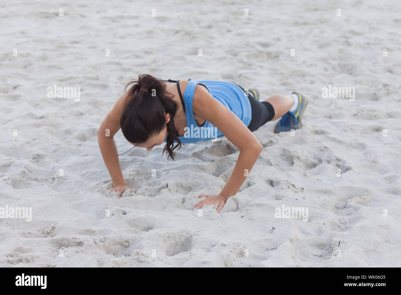 Woman doing push ups at beach Stock Photo