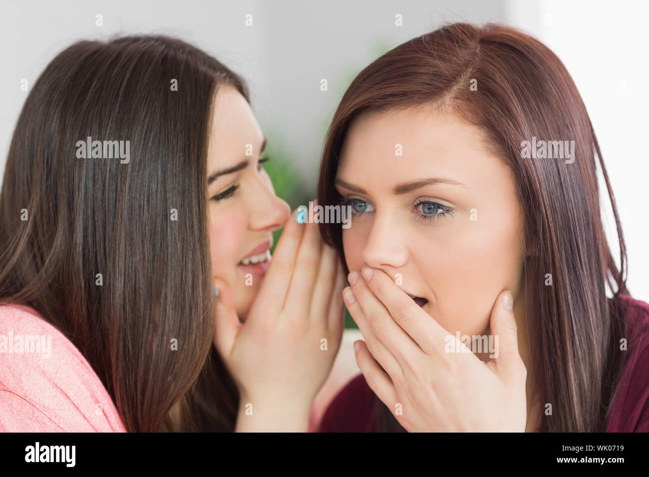 Two happy girls sharing secrets Stock Photo