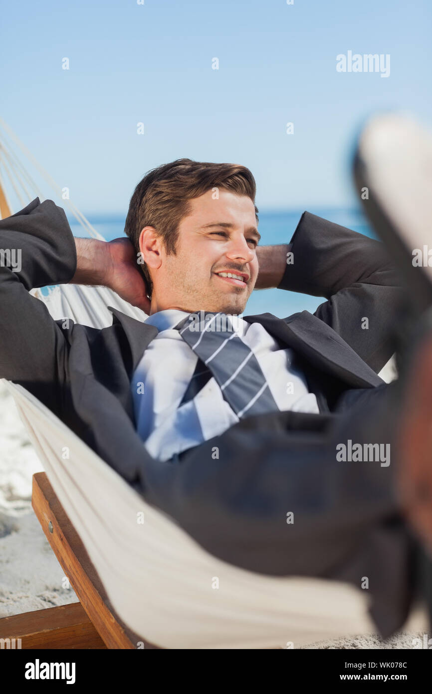 Happy businessman lying in hammock Stock Photo