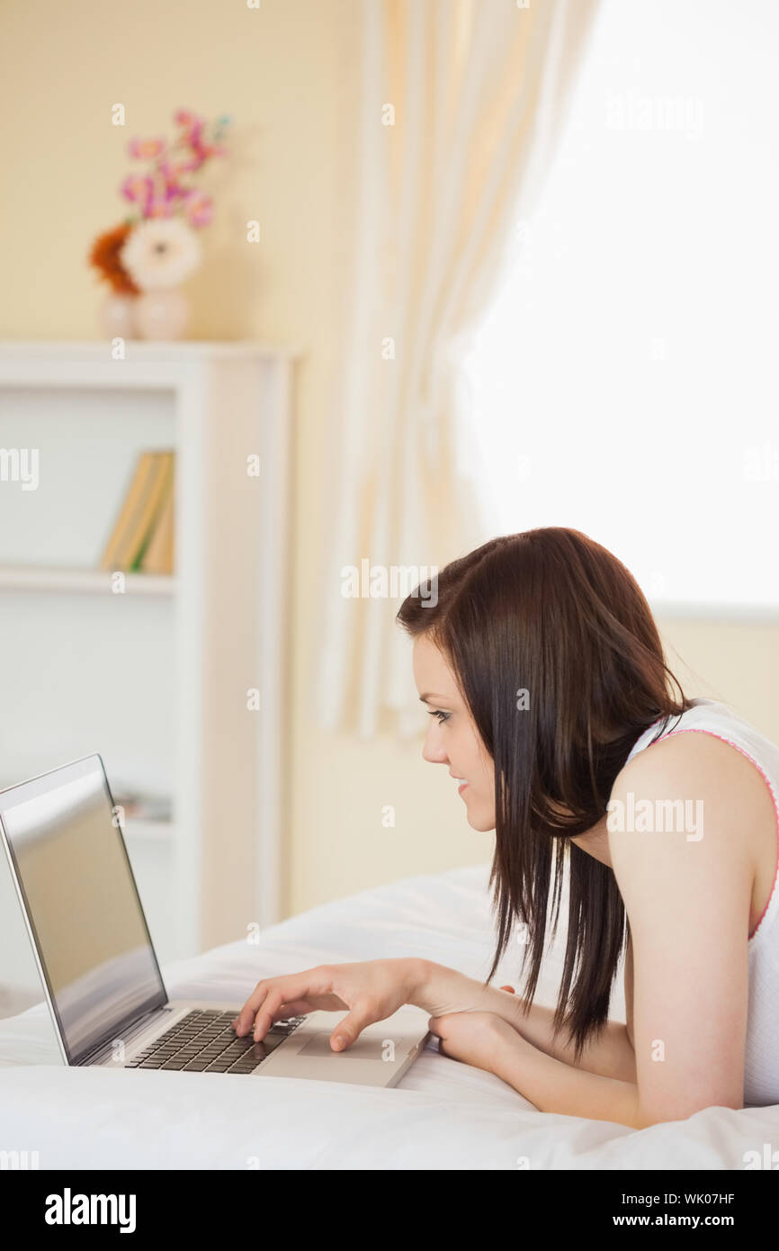 Pretty girl using a laptop lying on her bed Stock Photo - Alamy