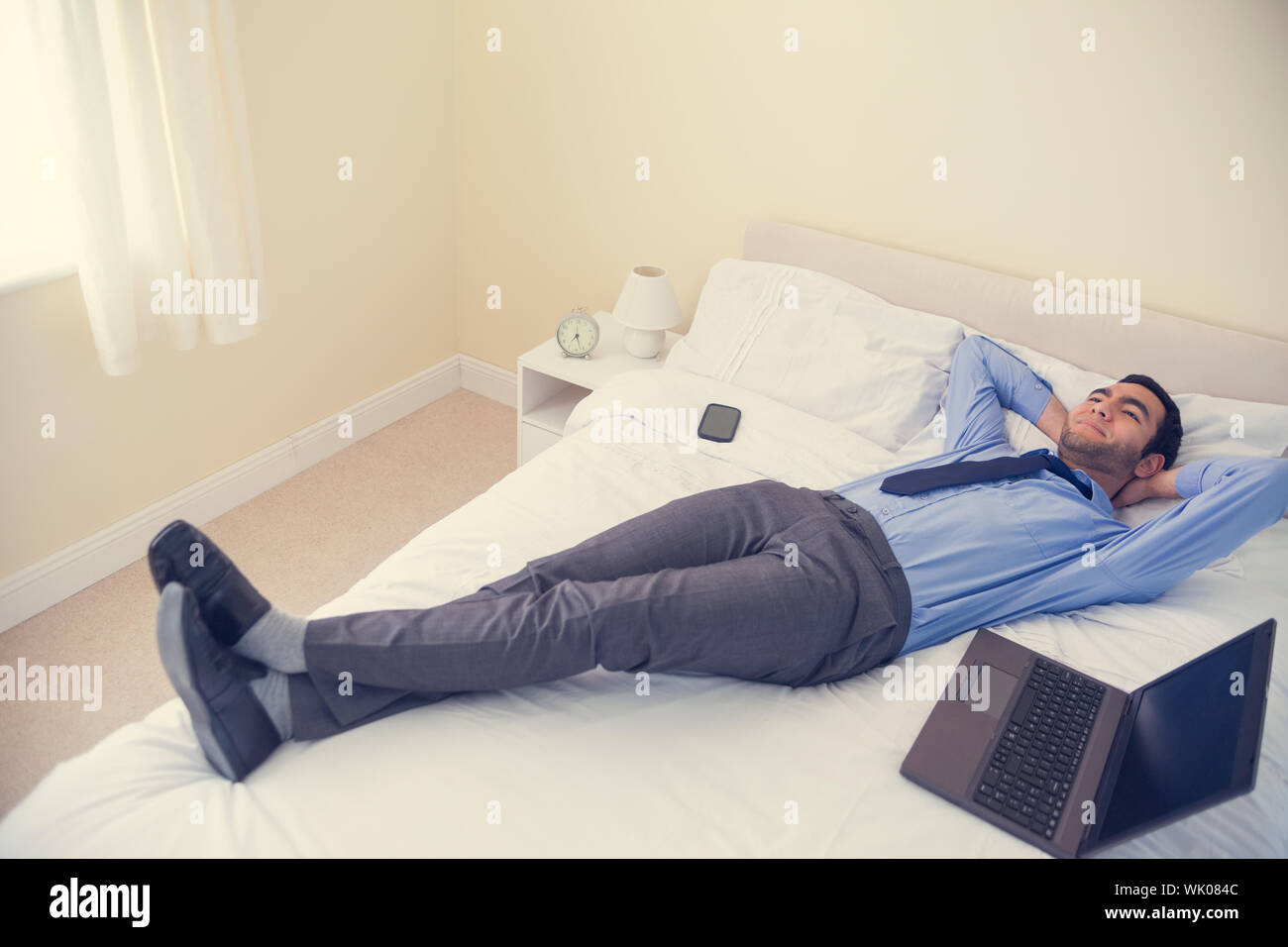 Pleased man relaxing on his bed Stock Photo