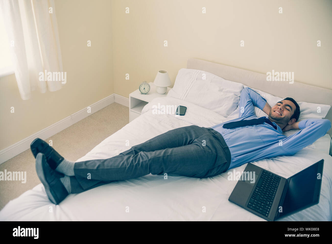 Cheerful man relaxing on his bed Stock Photo