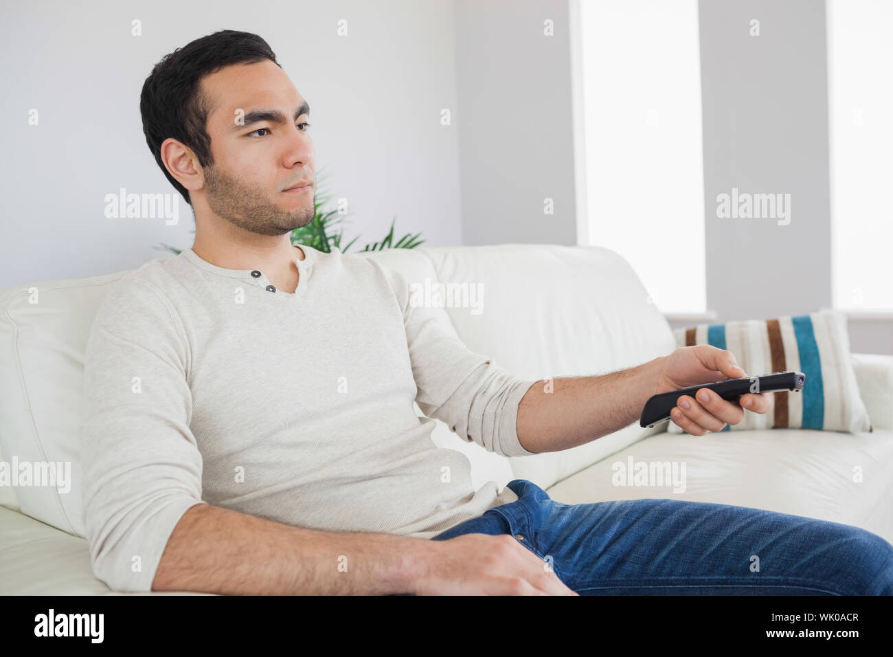 Serious man holding remote control Stock Photo