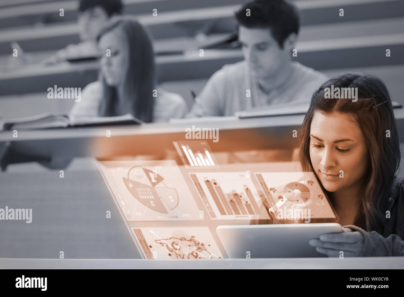 Student using tablet pc to take notes in lecture hall Stock Photo