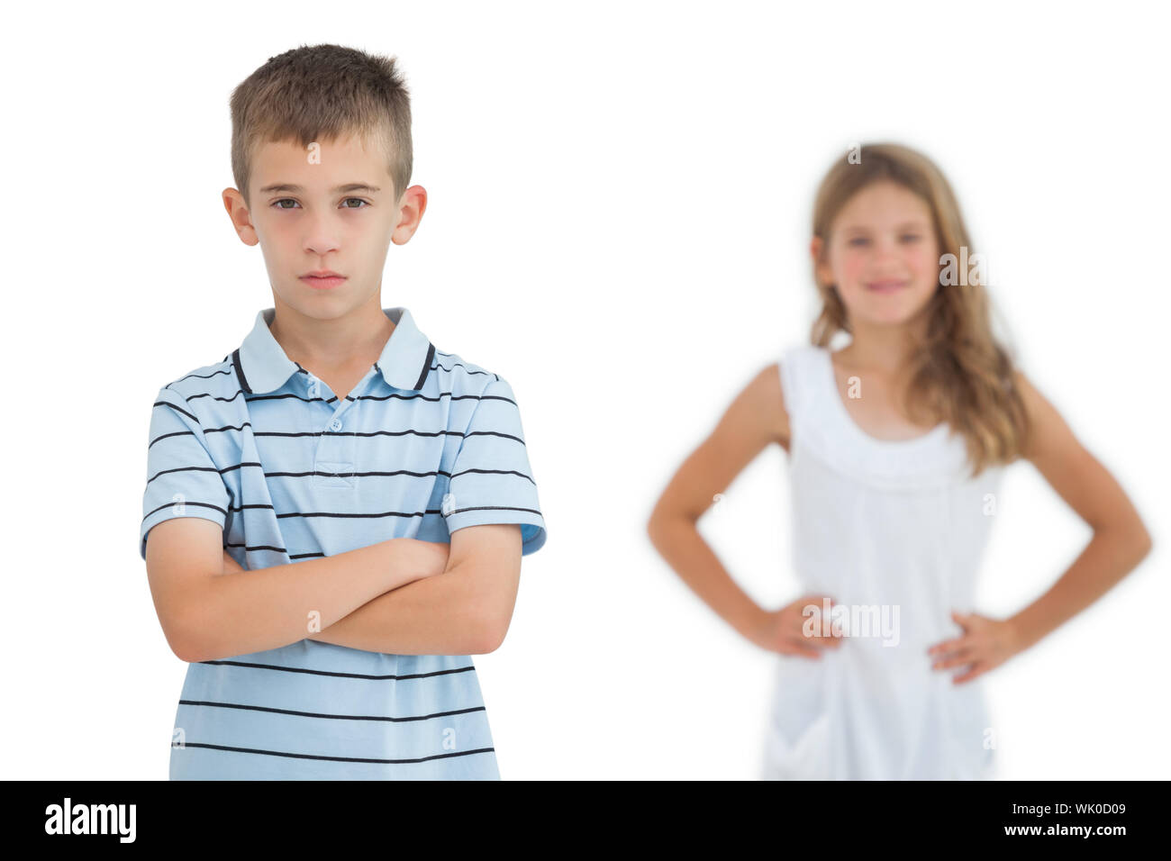 Serious child posing while his sister smiling Stock Photo