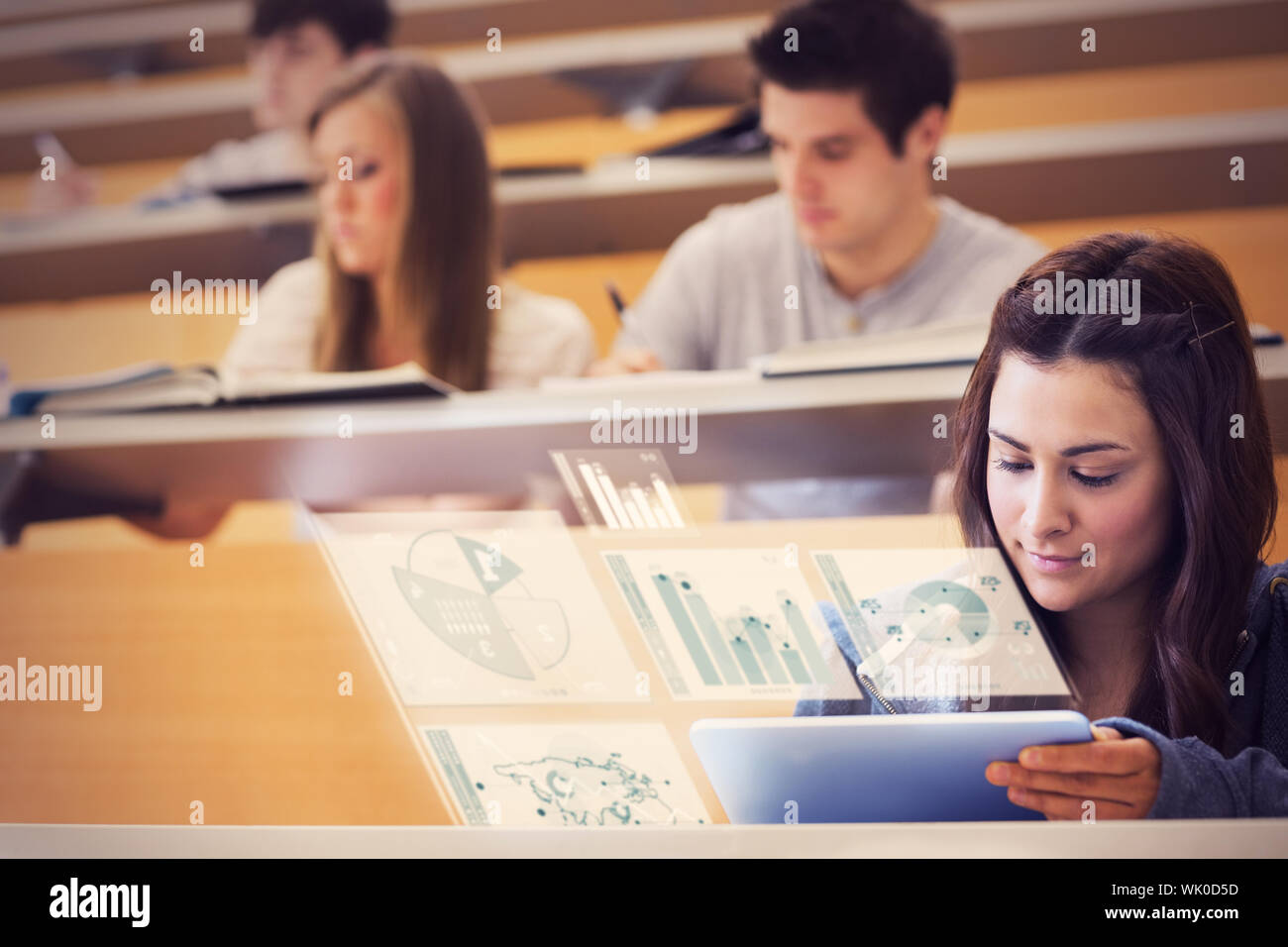 Student using tablet pc to take notes in lecture hall Stock Photo