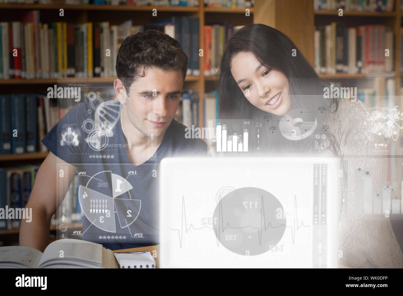 Smiling college friends studying on digital interface Stock Photo