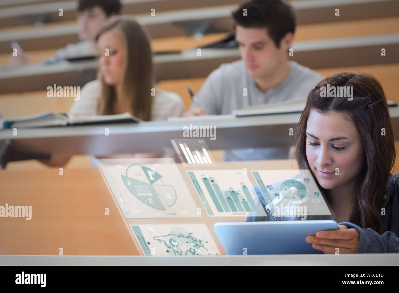 Student using tablet pc to take notes in lecture hall Stock Photo
