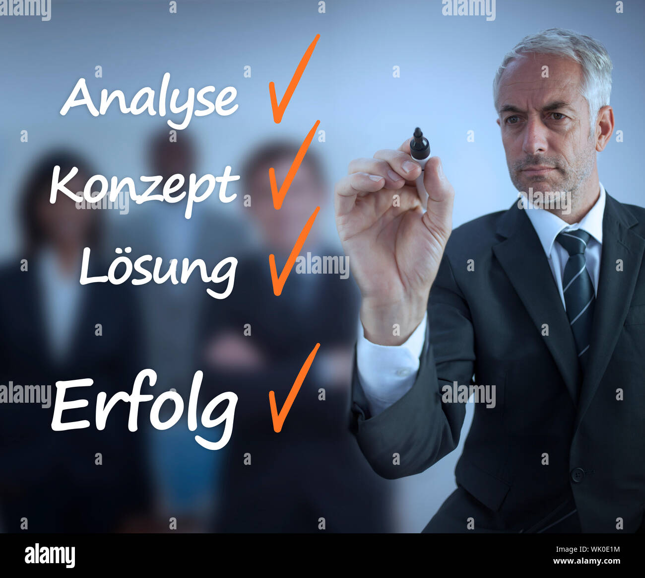 Businessman writing a success checklist in german Stock Photo
