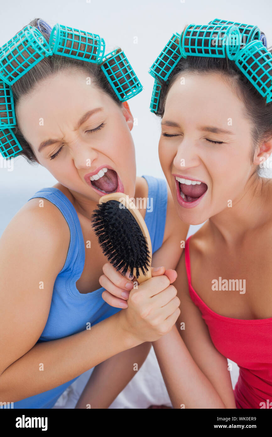 Friends in hair rollers holding hairbrush Stock Photo Alamy