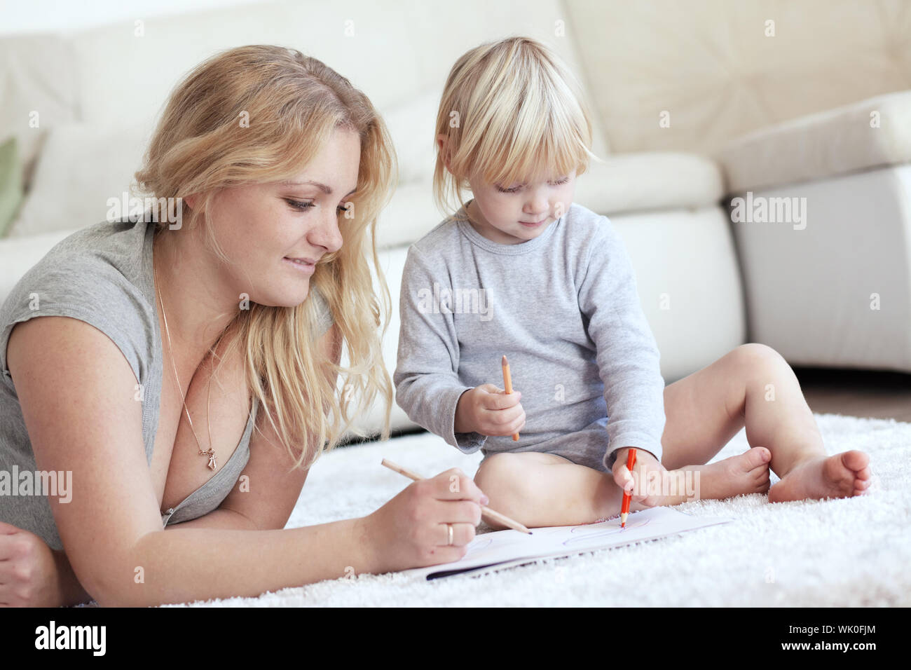 Mother With A Child Drawing Together At Home Stock Photo