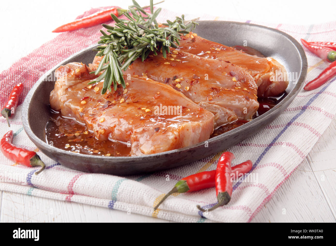 marinated pork chops with rosemary and crushed chili in a pan Stock