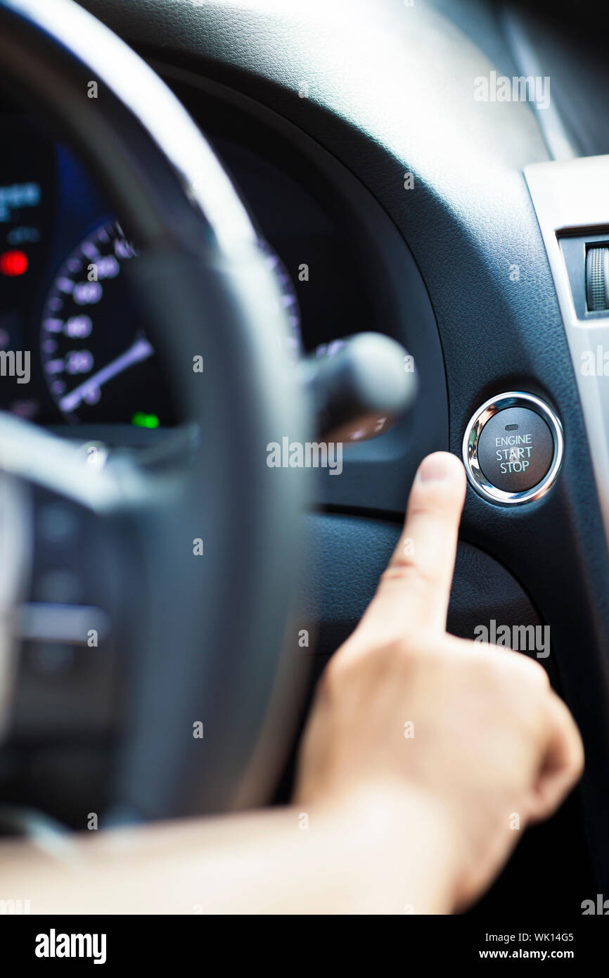 finger pressing the Engine start stop button Stock Photo