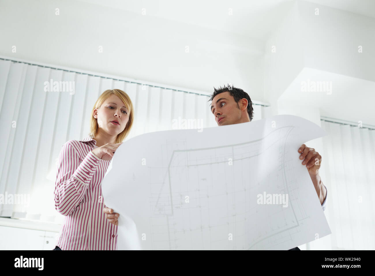two architects examining blueprint indoors. Low angle view. Copy space Stock Photo