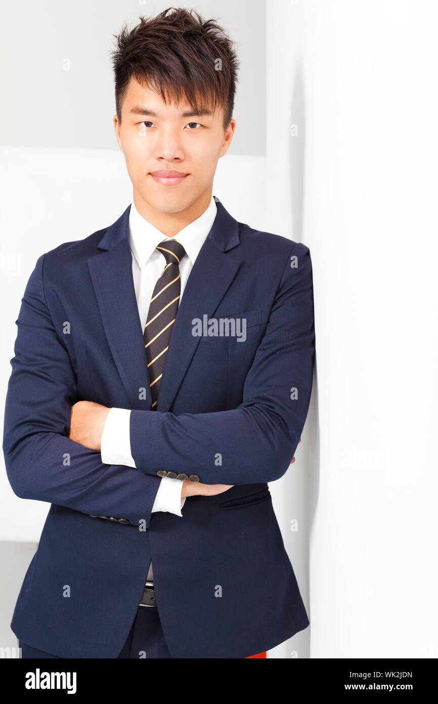 confident businessman cross arms with wall Stock Photo