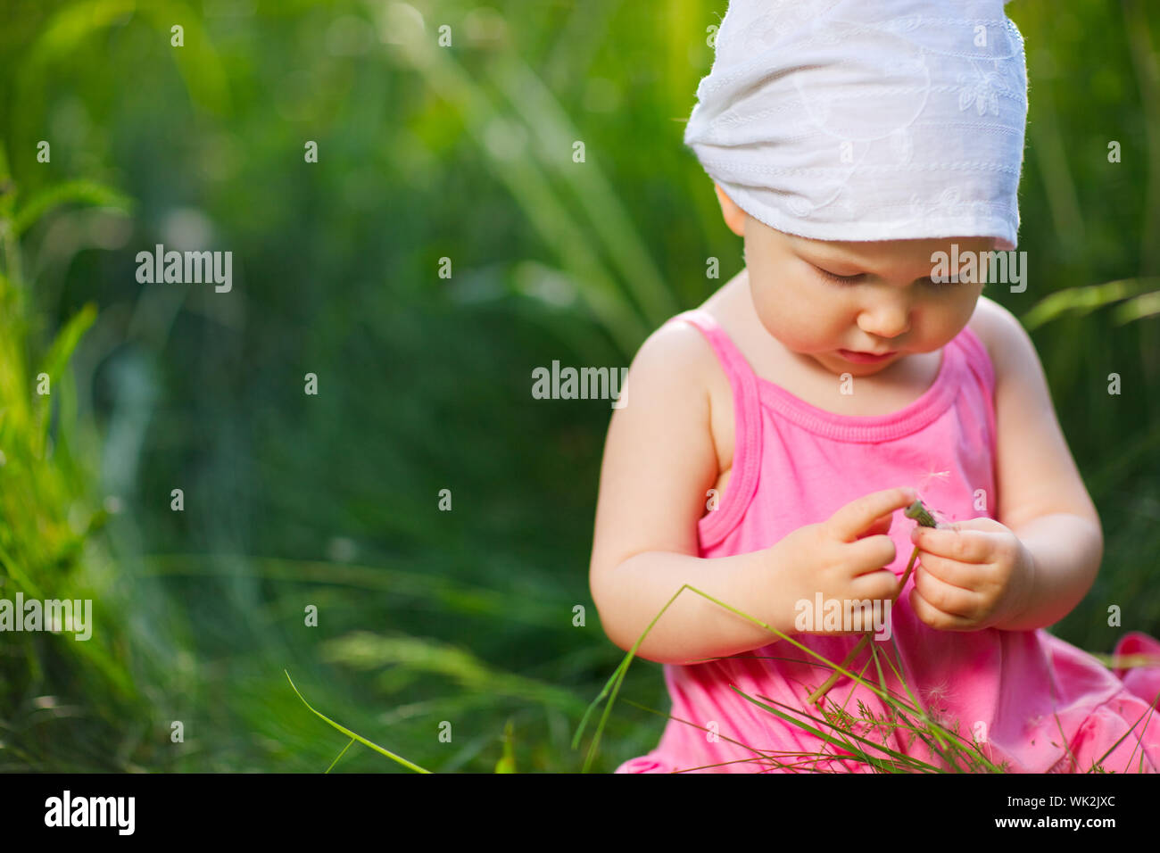 Cute little girl in meadow at sunny summer day Stock Photo - Alamy