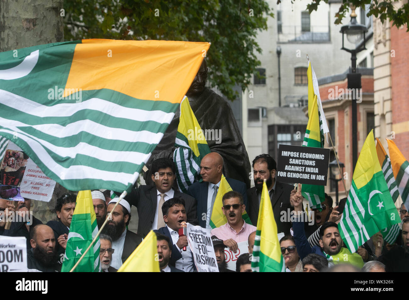 London, UK. 03rd Sep, 2019. Kashmiri protesters wave flags in front of the statue of Gandhi in Parliament Square in solidarity with the people of Kashmir after Indian Prime Minister Narendra Modi delivered an Independence Day speech to remove the special rights of Kashmir as an autonomous region. Credit: SOPA Images Limited/Alamy Live News Stock Photo