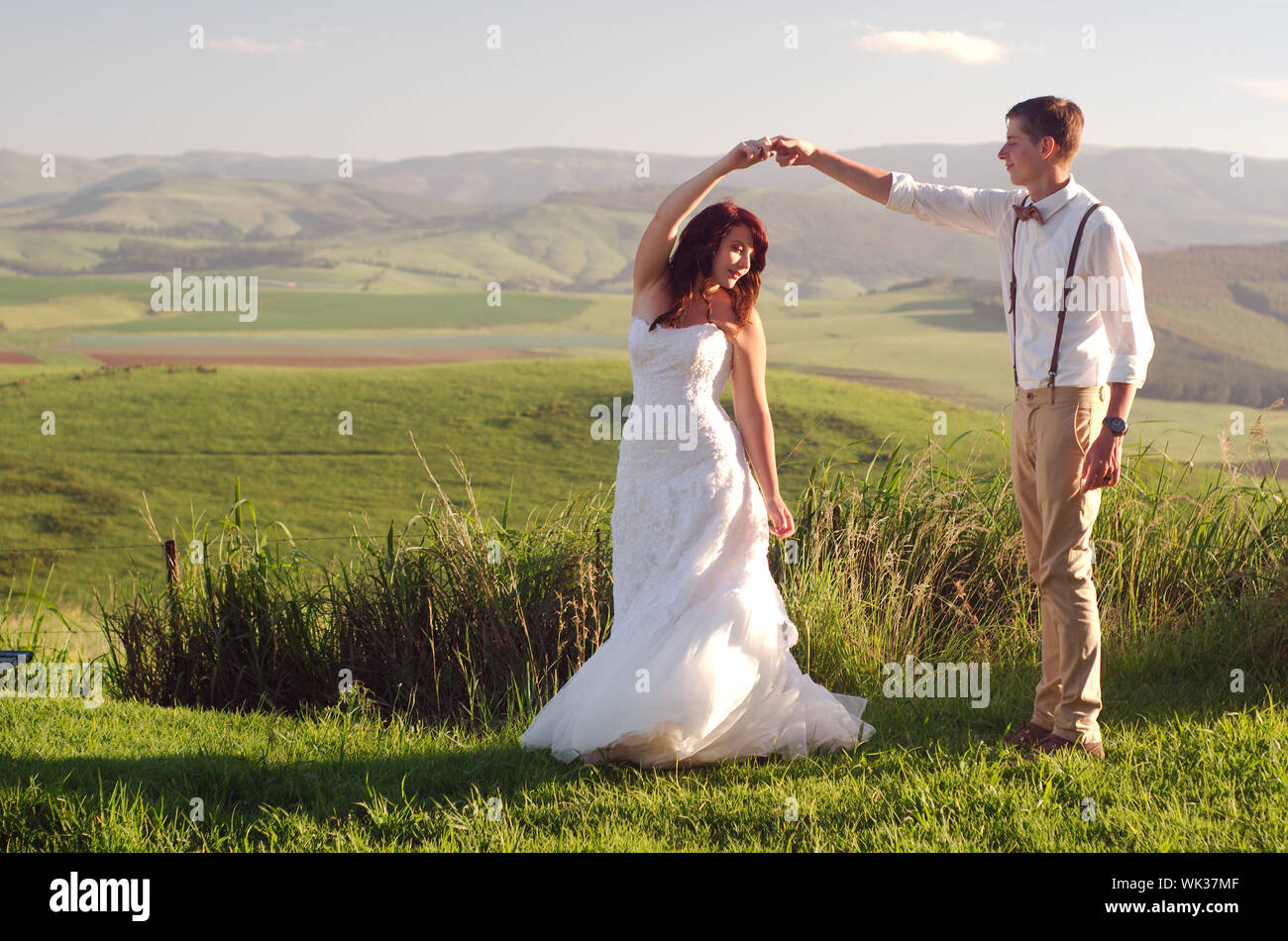 Bride and groom outside garden wedding with African Natal Midlands mountain scenery background Stock Photo