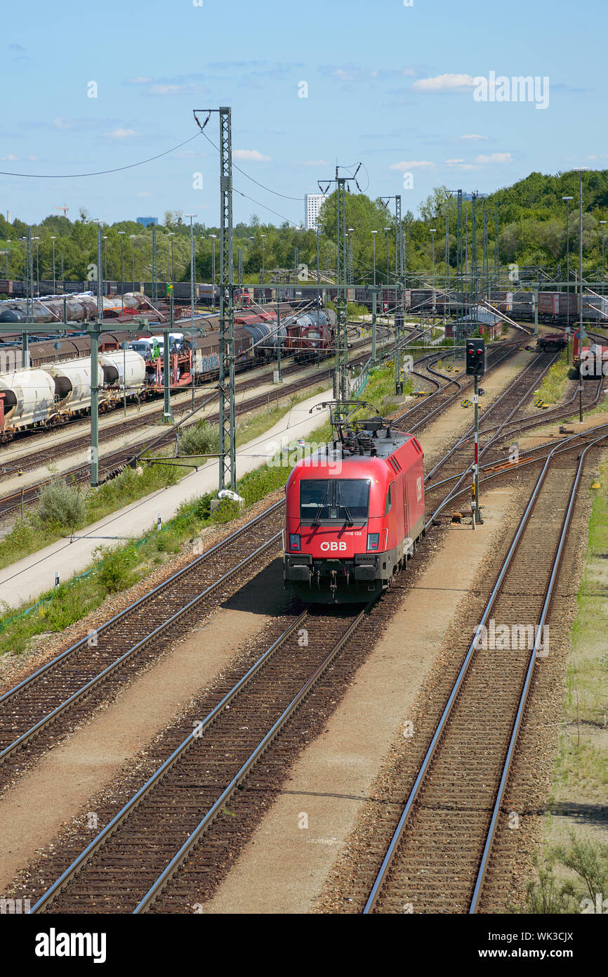 Munich, Germany - July 10, 2019: Red locomotive of Oebb transportation company moving through railroad cargo marshalling station Stock Photo