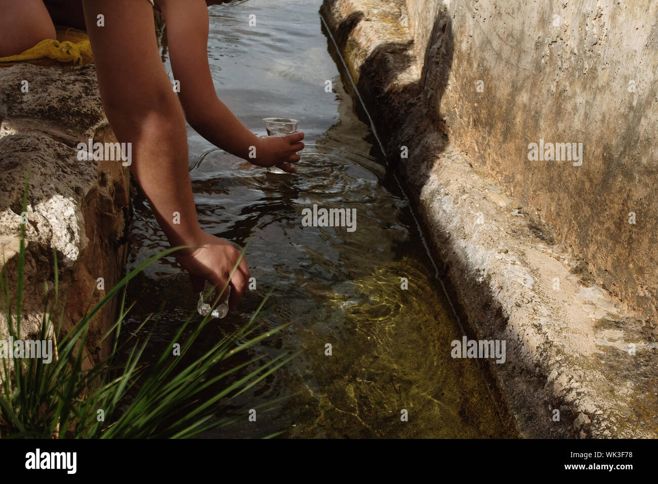 Cropped Image Of Hands Filling Water From Gutter Stock Photo