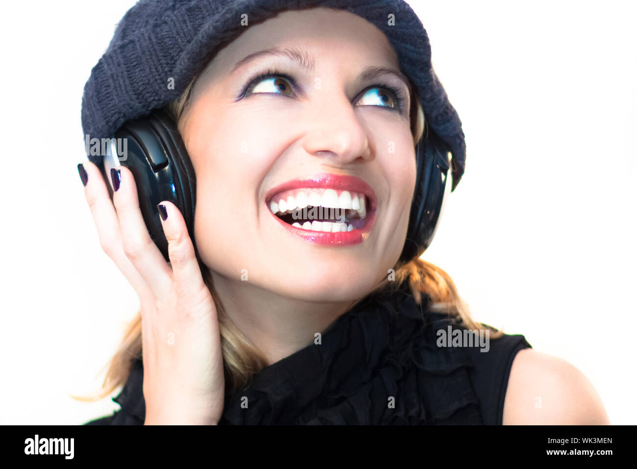 Blonde caucasian girl listening to the music with a pair of headphones ...