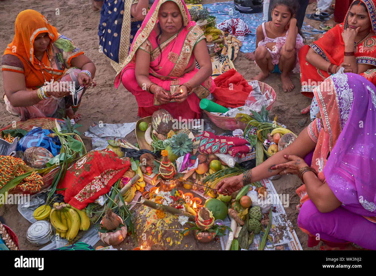 Women at Chowpatty Beach, Mumbai, India, celebrating Chhath Puja with sacrificial offerings to assure the health and long lives of their husbands Stock Photo