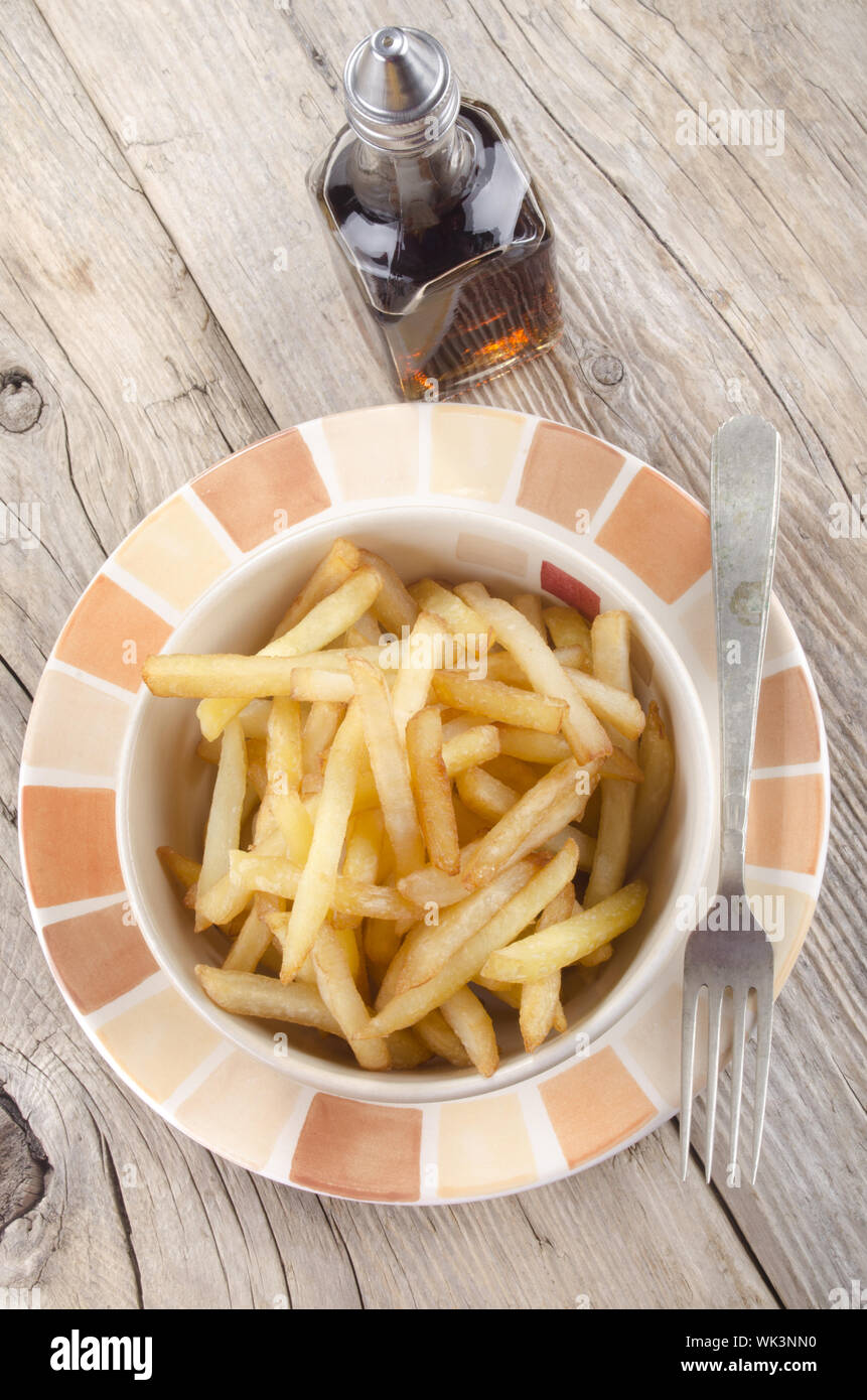 french fries and malt vinegar on a rustic table Stock Photo Alamy