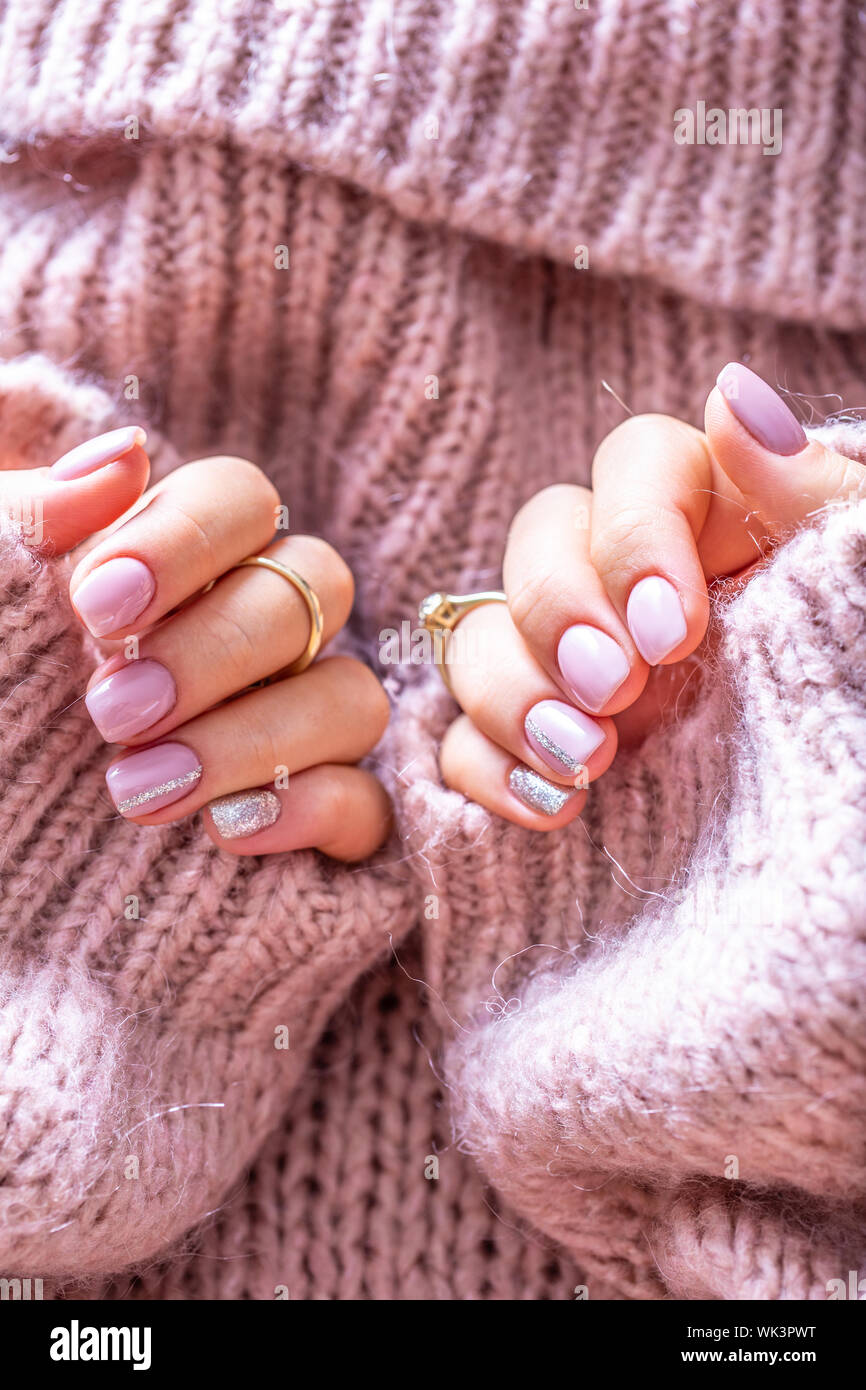 Art nail manicure for bride in purple sweater. Gel nails in soft pink color Stock Photo