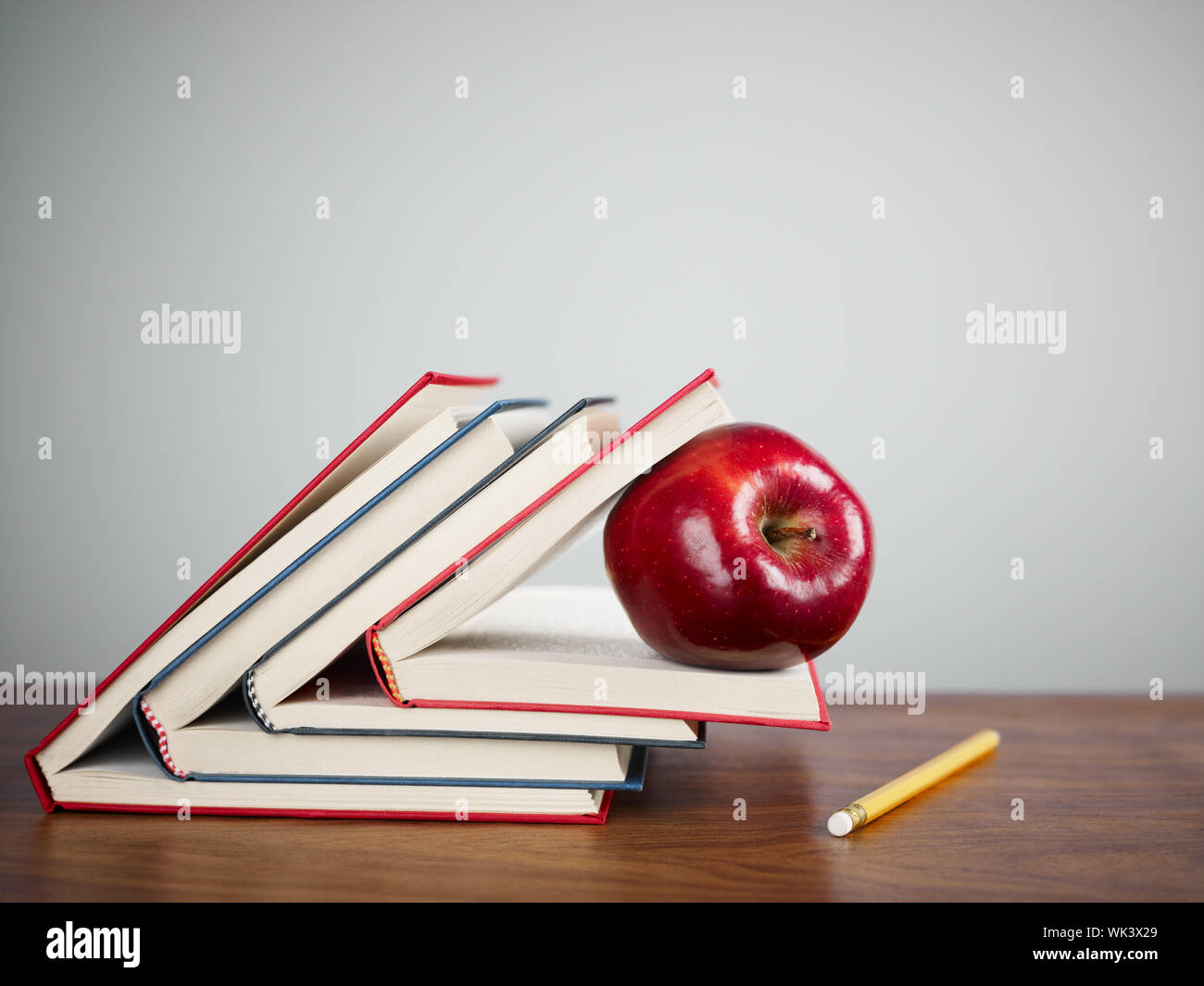 Pile Of Books And Red Apple On Desk Copy Space Stock Photo