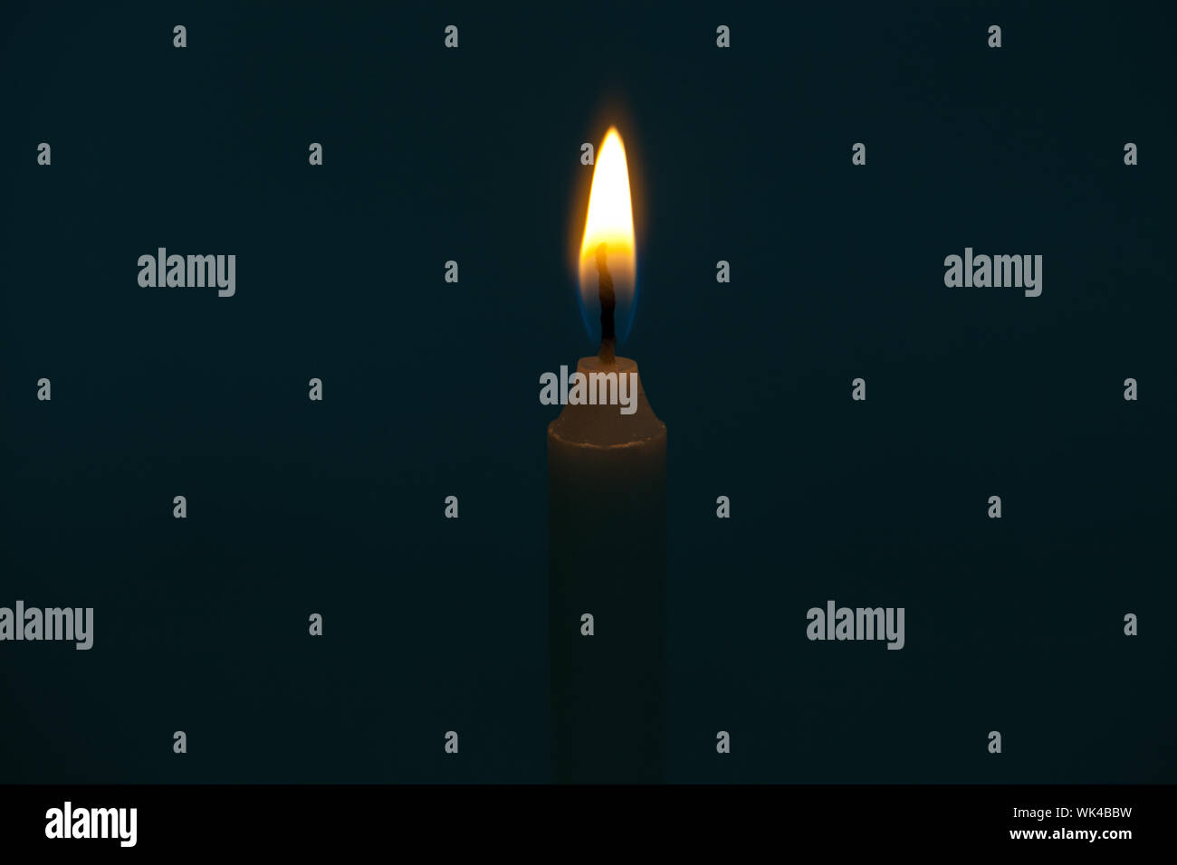 Close up of a burning candle in a dark room Stock Photo Alamy