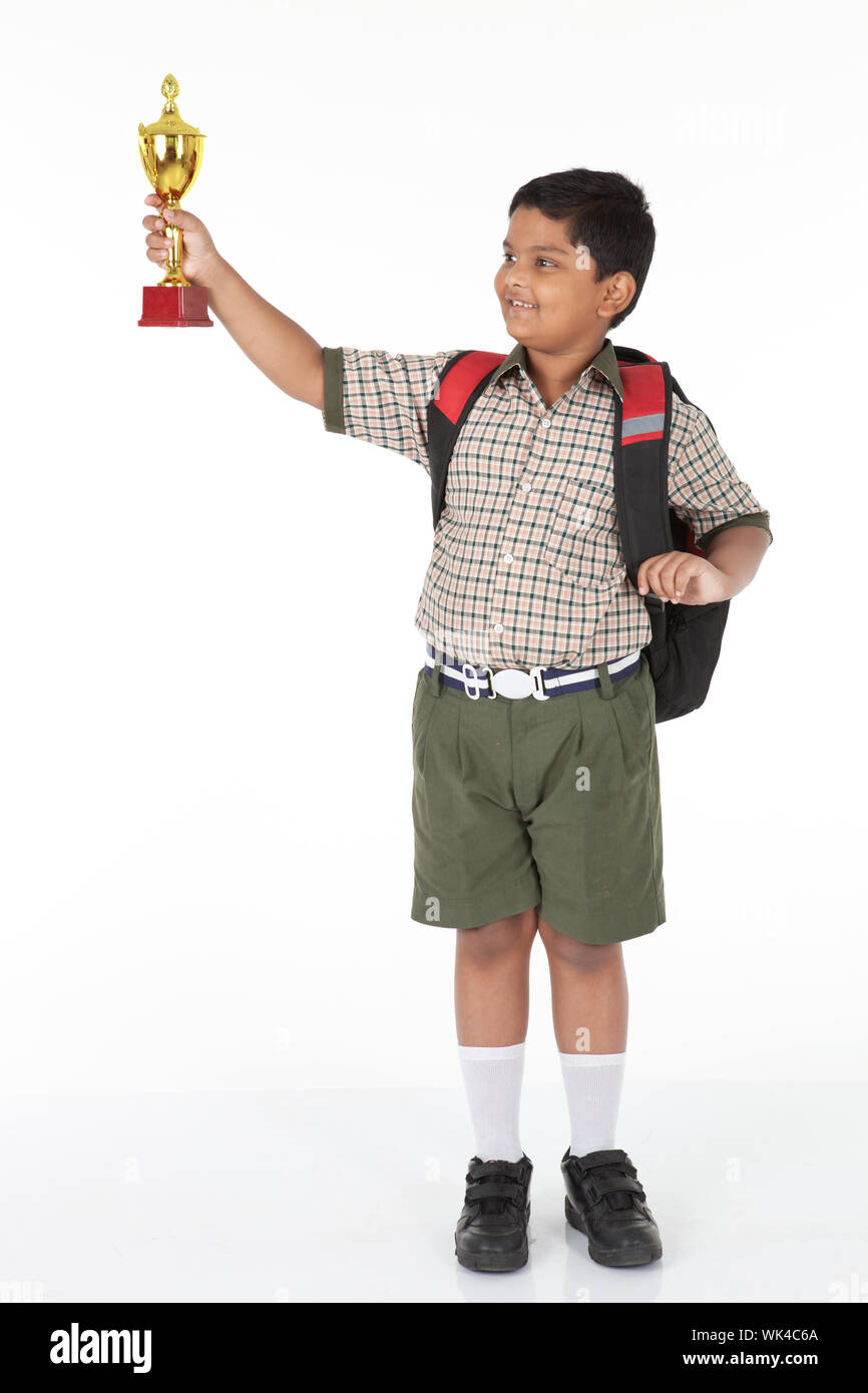 Indian schoolboy showing a trophy and smiling Stock Photo